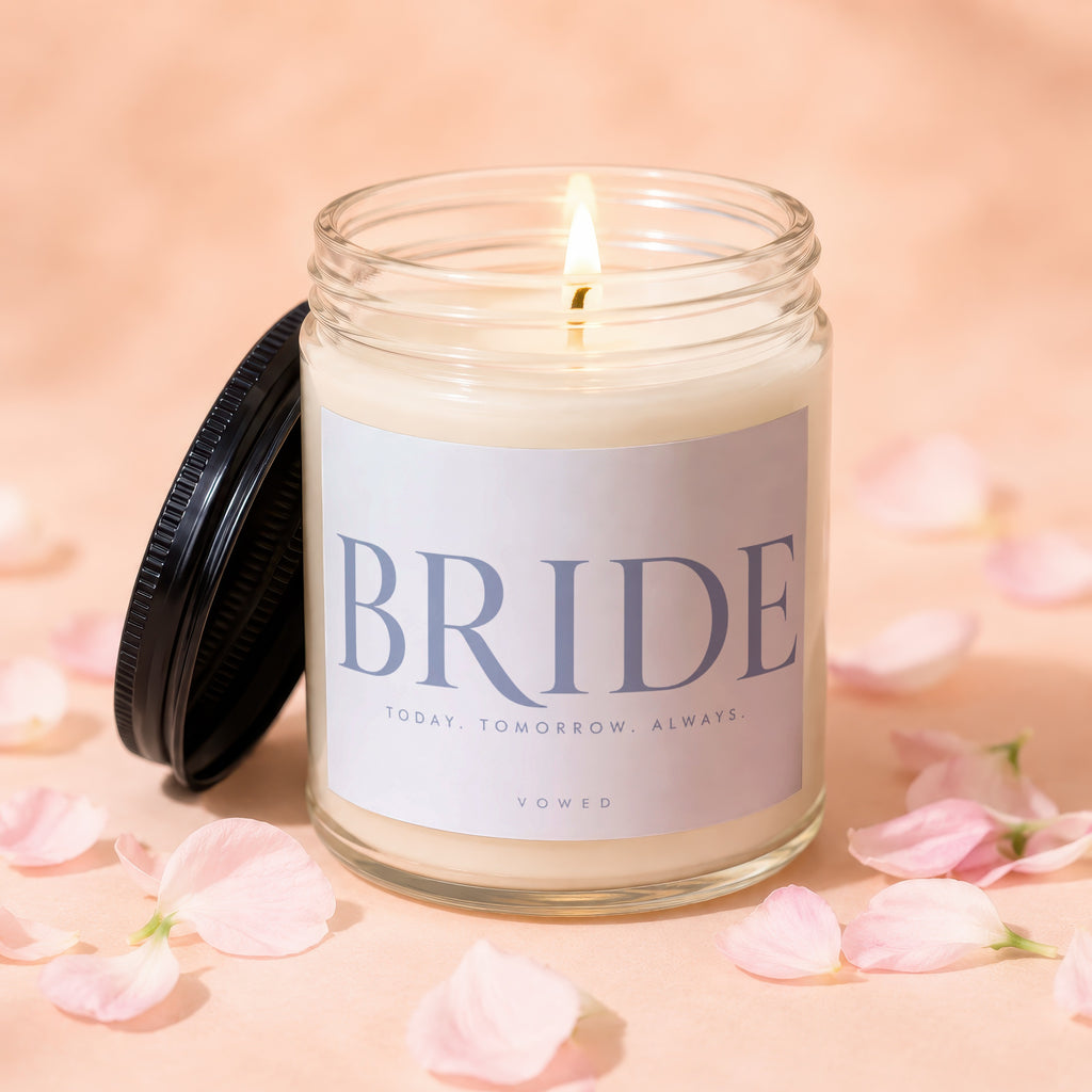 Lit candle in a glass jar with black lid, labeled "BRIDE TODAY. TOMORROW. ALWAYS. VOWED."