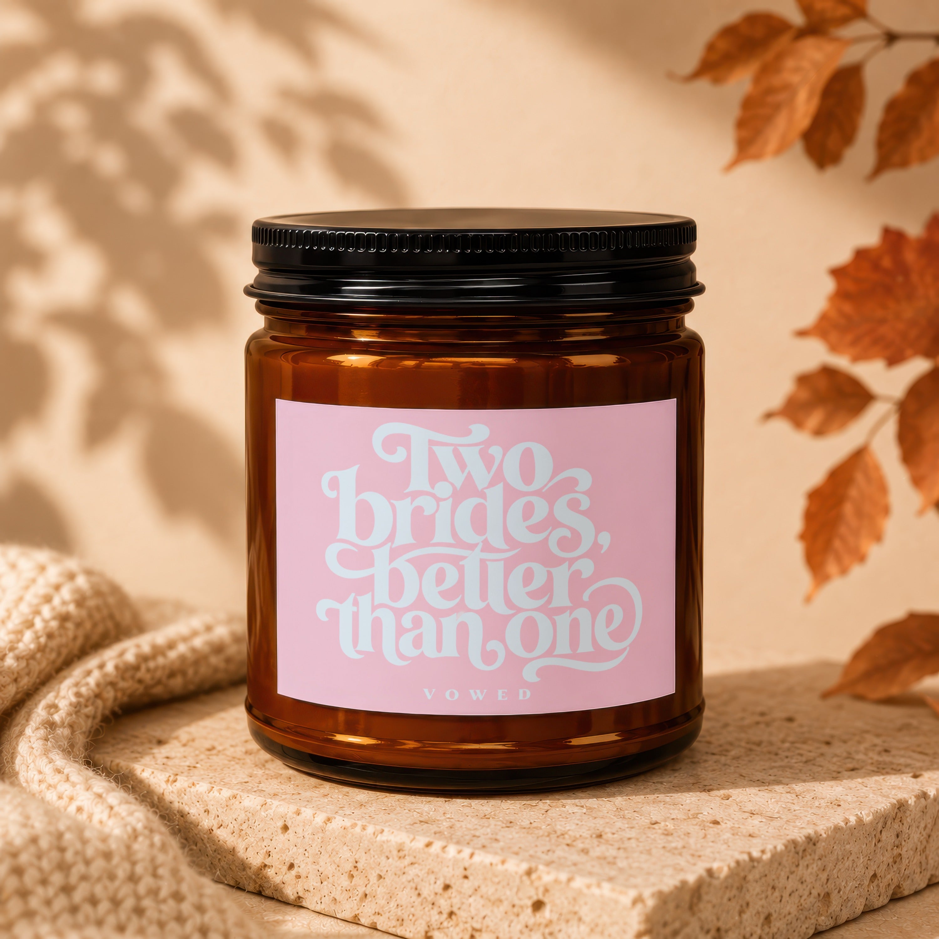Amber candle with pink label that reads "Two brides, better than one" and "VOWED".