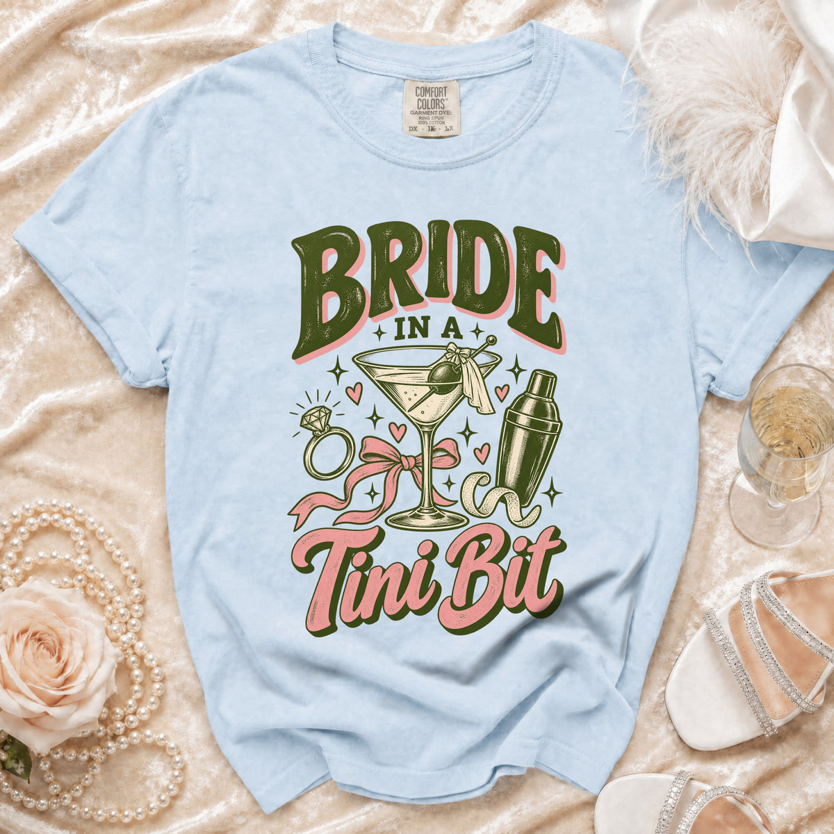 Light blue t-shirt with "BRIDE IN A Tini Bit" text and cocktail graphic.