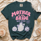 A dark teal crewneck t-shirt featuring pink and purple Halloween wedding graphics and text reading "MOTHER OF THE BRIDE boo crew".