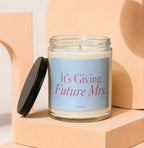 Glass candle with "It's Giving Future Mrs." text and "VOWED" logo.