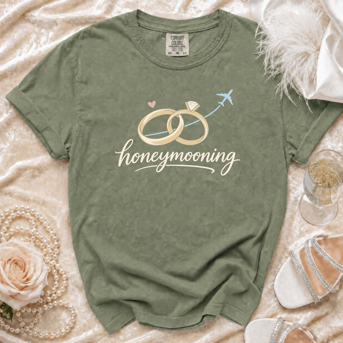 Olive green t-shirt with "honeymooning" text and wedding rings graphic.