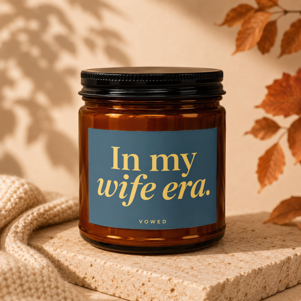 Amber jar candle with navy label saying "In my wife era."