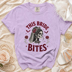 Purple t-shirt with "This Bride Bites" graphic of a skull bride and roses.