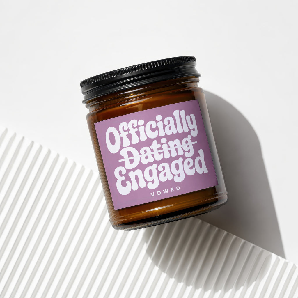Candle with "Officially Dating Engaged" text on a lavender label.