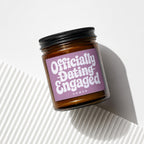 Candle with "Officially Dating Engaged" text on a lavender label.