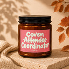 Amber jar candle with pink label reading "Coven Attendee Coordinator VOWED".