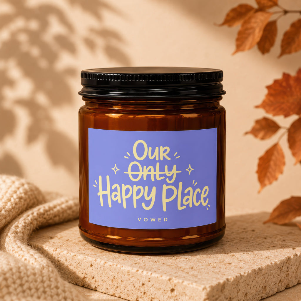 Brown glass candle with a purple label reading "Our Only Happy Place" by Vowed.