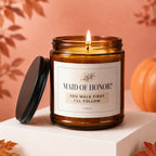 Amber glass candle with lid off, reading "Maid of Honor? You walk first. I'll follow."