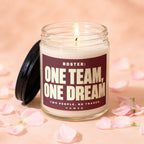 Jar candle with lit wick, black lid off, "ROSTER: ONE TEAM, ONE DREAM" text.