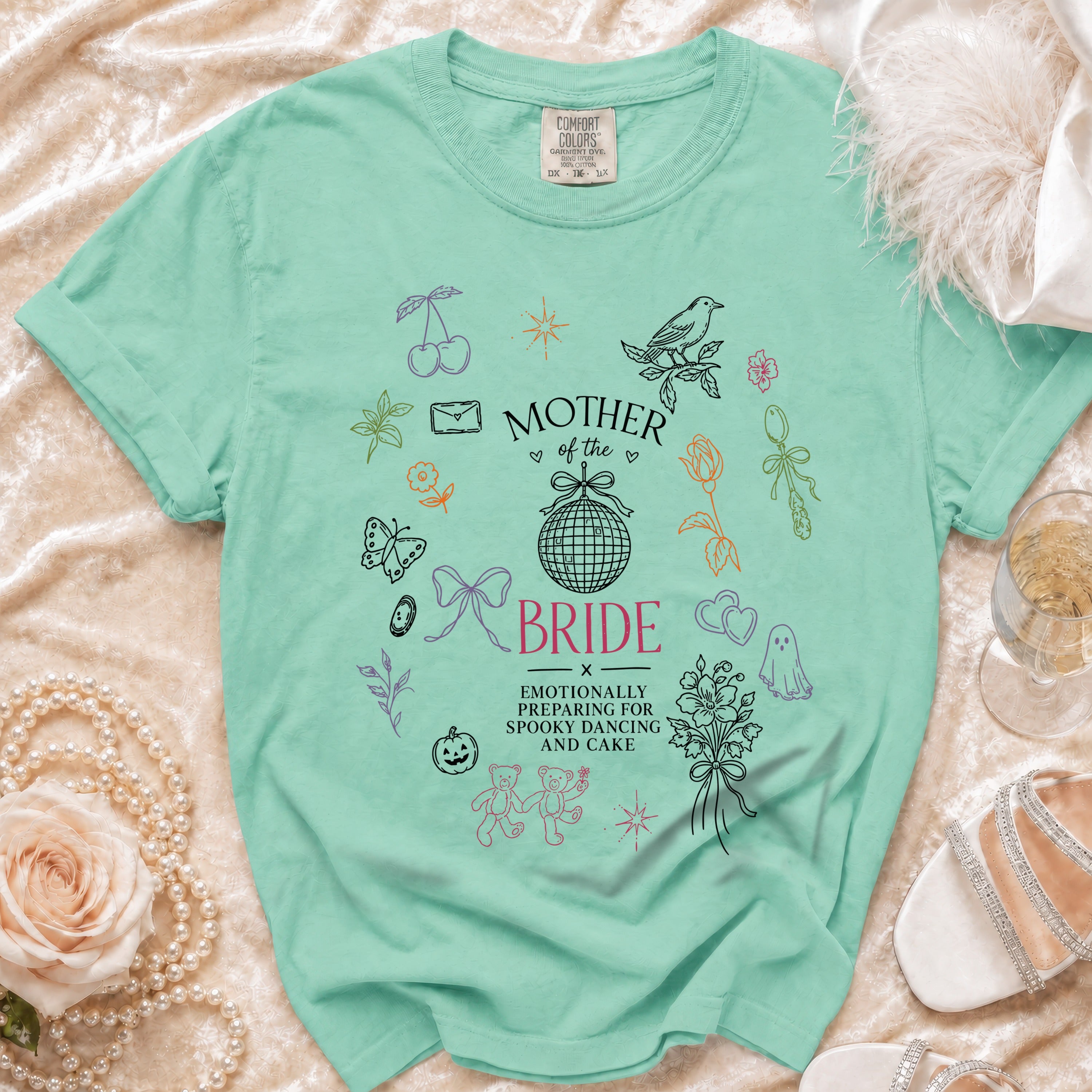Mint t-shirt with "Mother of the Bride" and graphics of teddy bears, ghost, and disco ball.