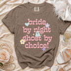 Brown t-shirt with pink text "bride by night ghost by choice" and cartoon graphics.