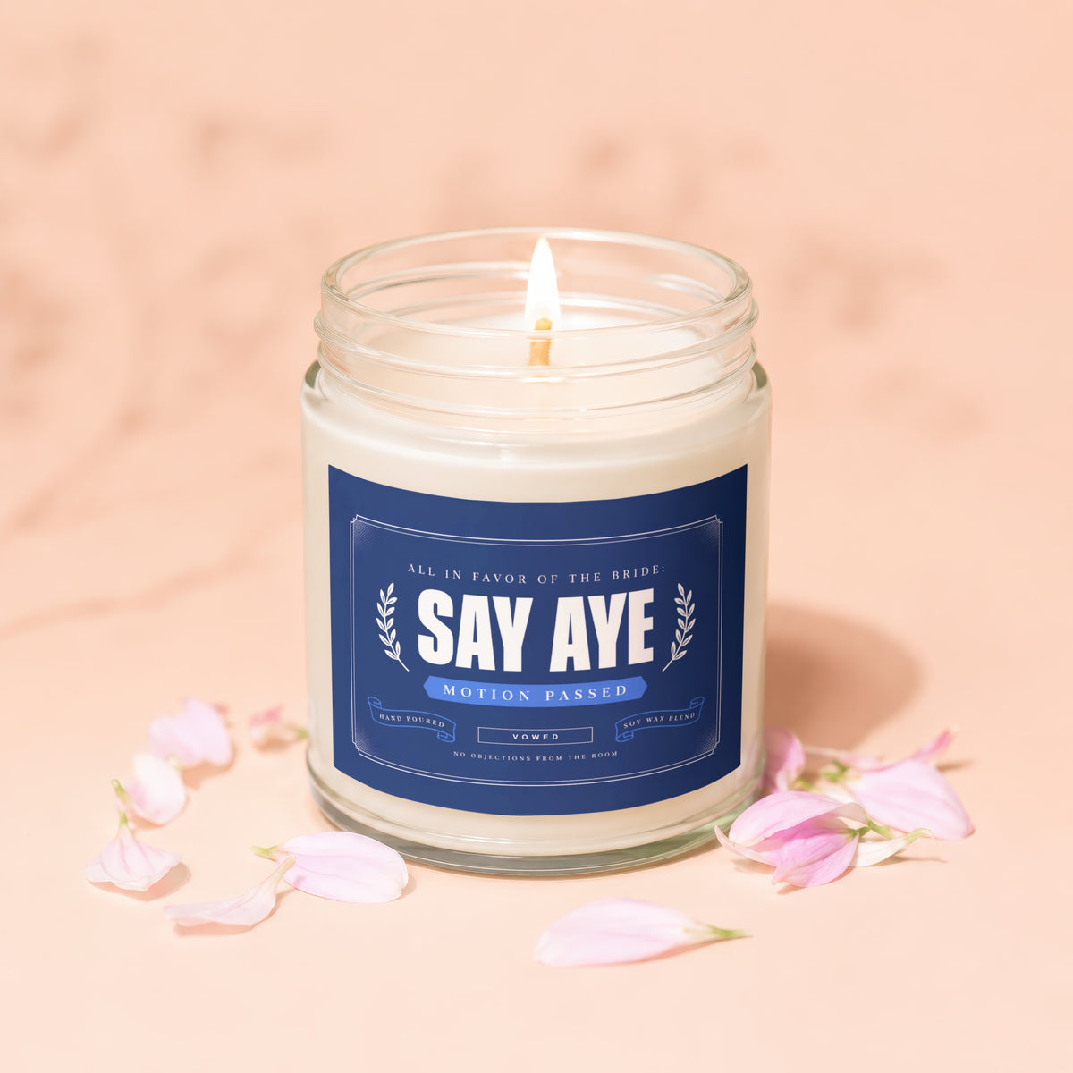 Glass candle with navy label reading "SAY AYE MOTION PASSED" and "VOWED".