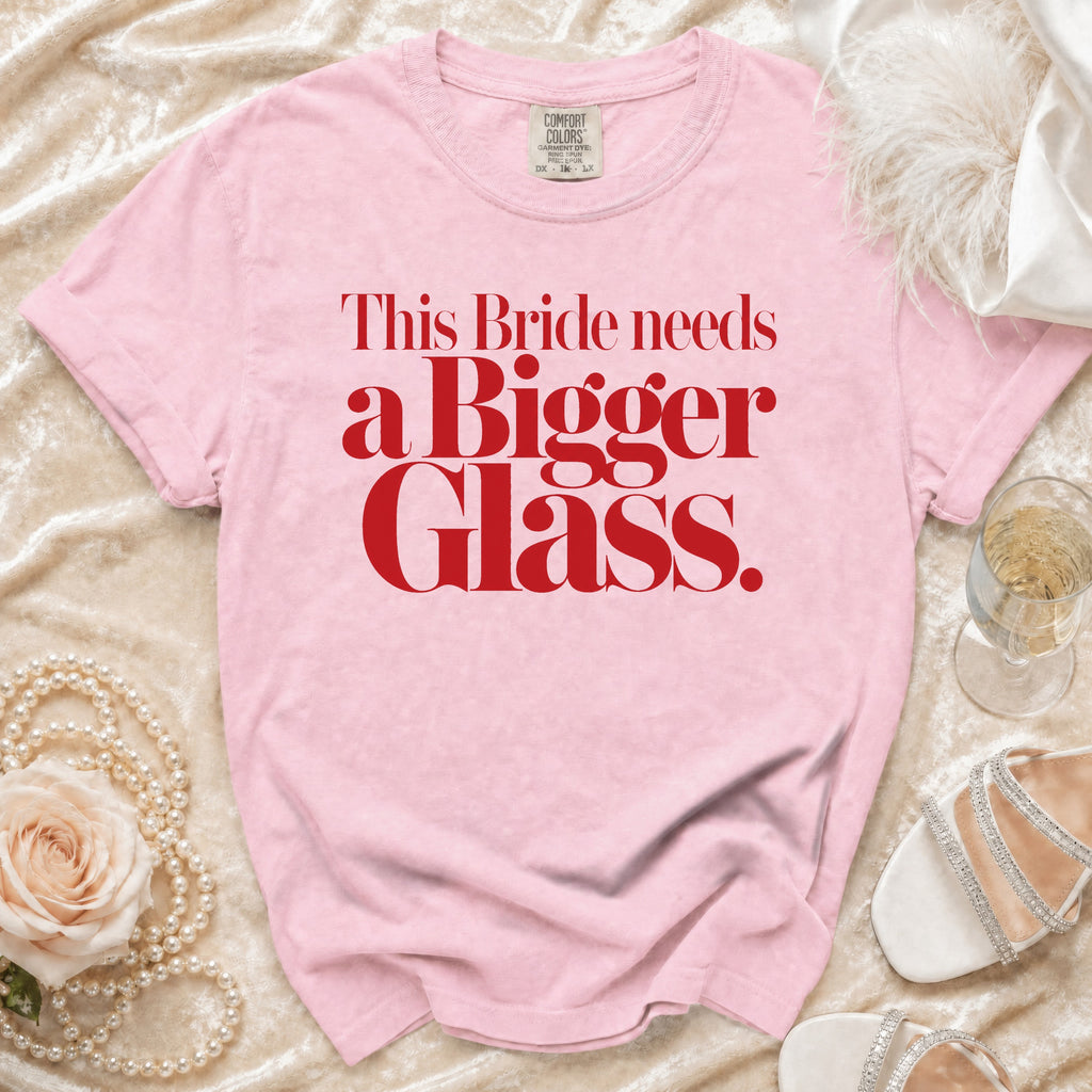 Pink t-shirt with red text: "This Bride needs a Bigger Glass."