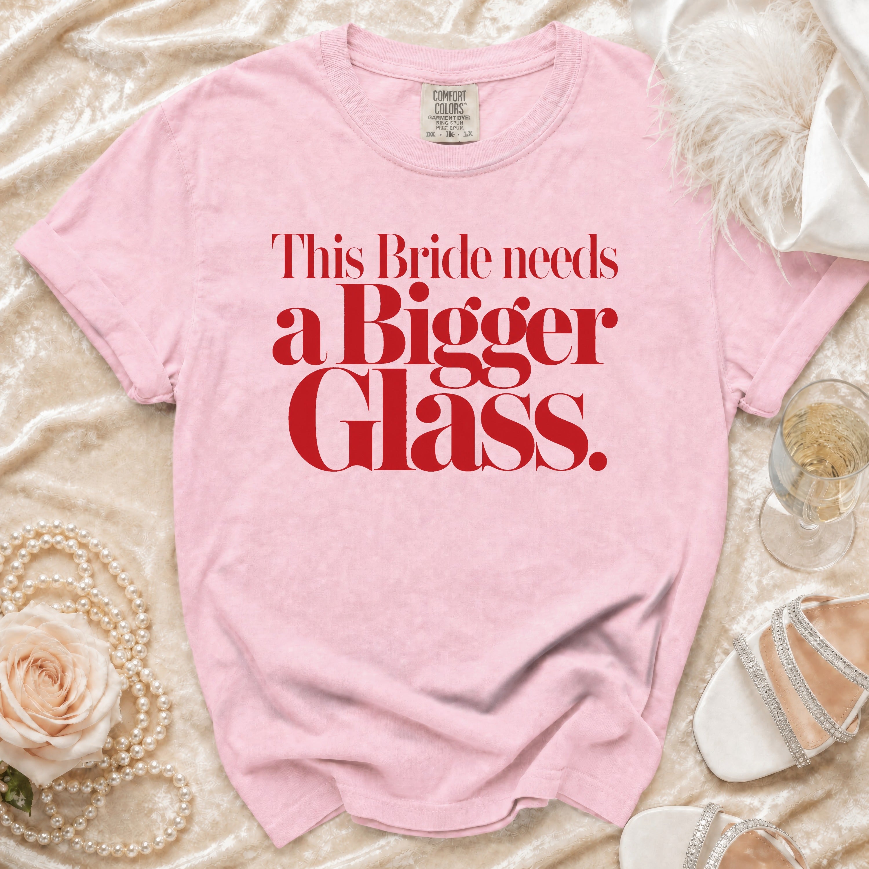 Pink t-shirt with red text: "This Bride needs a Bigger Glass."