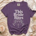 Purple t-shirt with "This Bride Bites" text and vampire-themed graphic.