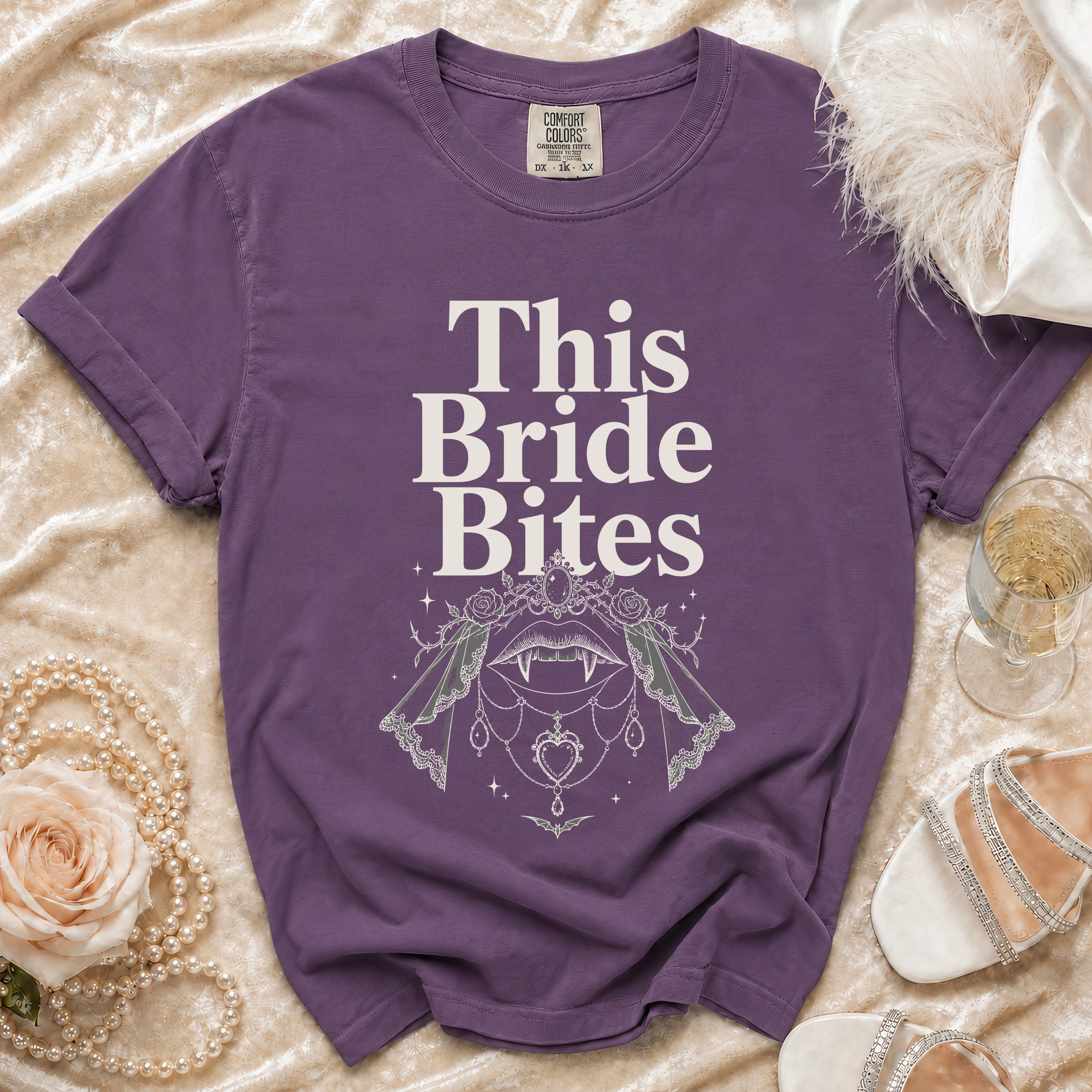 Purple t-shirt with "This Bride Bites" text and vampire-themed graphic.