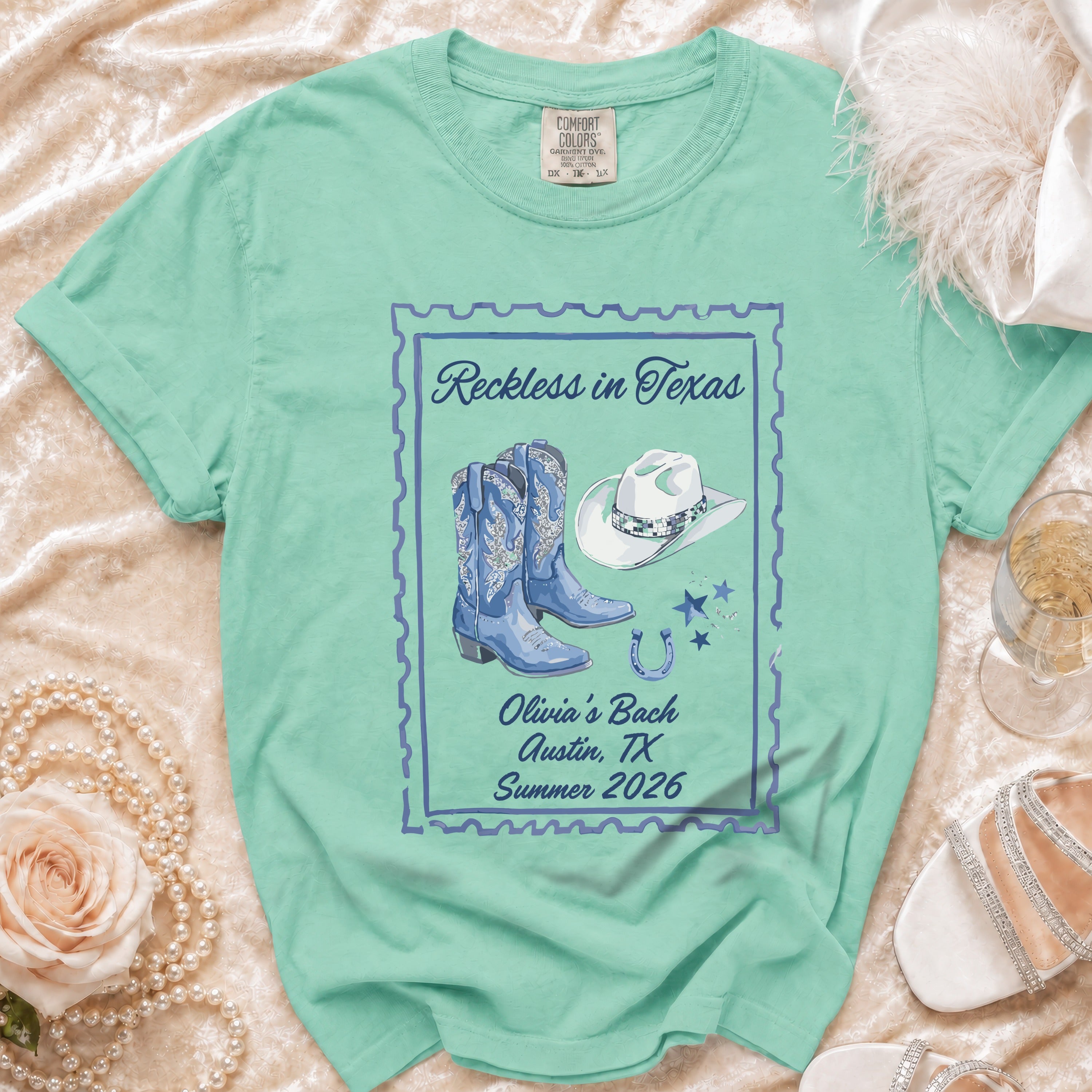 Teal t-shirt with "Reckless in Texas Olivia's Bach Austin, TX Summer 2026"