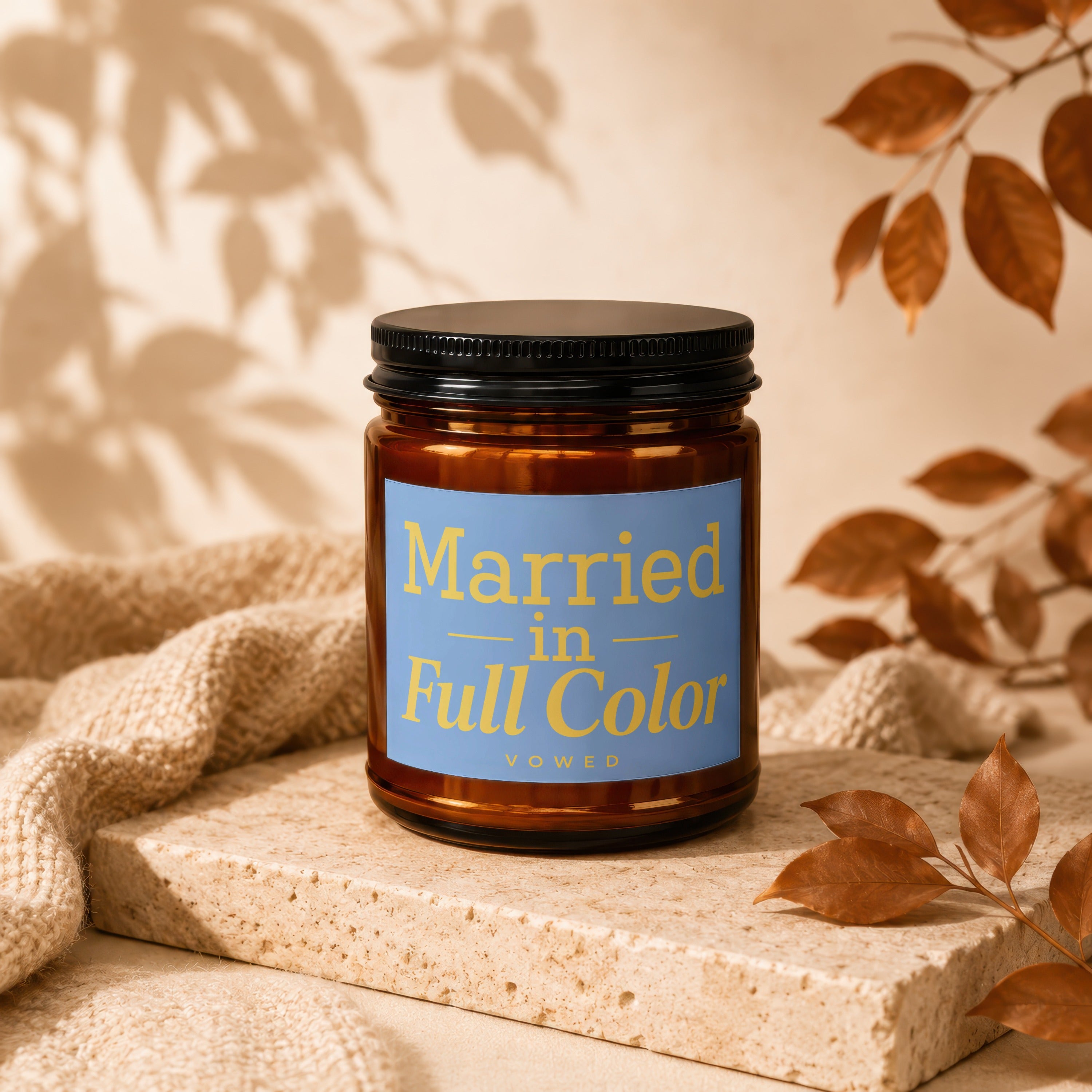 Amber candle with a black lid and a blue label reading "Married in Full Color VOWED".