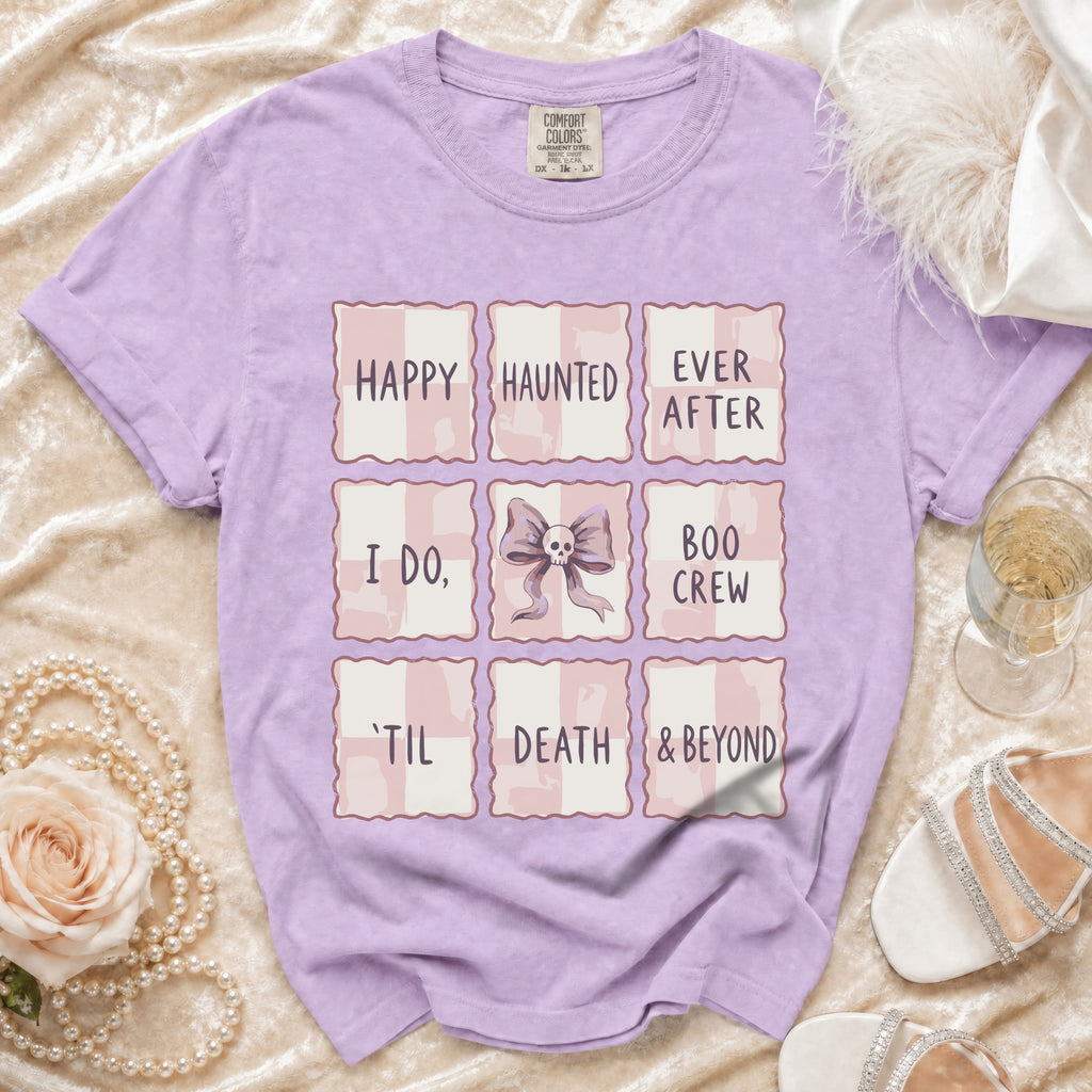 Lavender Comfort Colors t-shirt with grid design featuring "Happy Haunted Ever After," "I Do," skull bow, "Boo Crew," "'Til Death & Beyond."