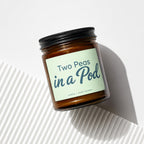 Amber candle in a jar labeled "Two Peas in a Pod | VOWED | HAND POURED".