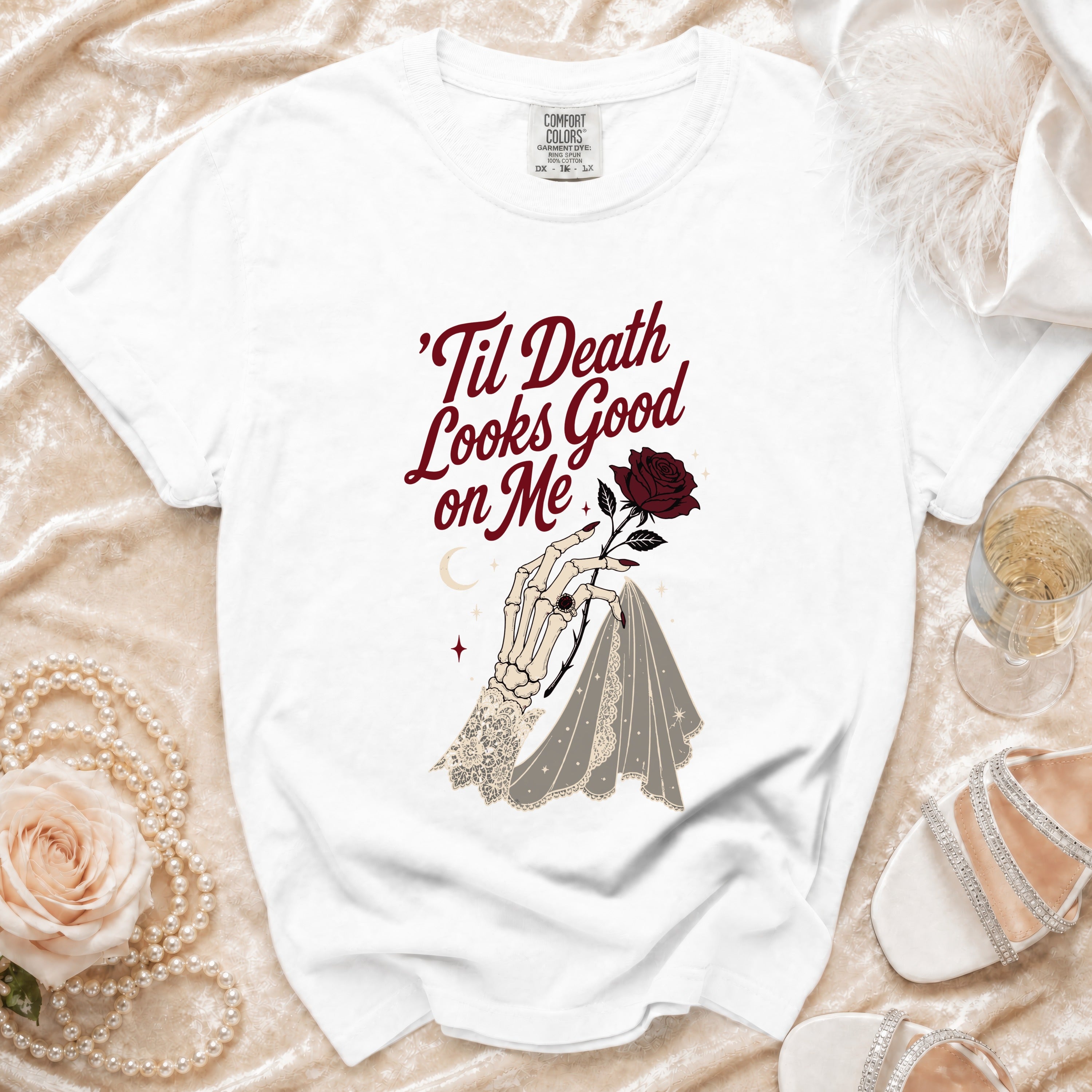 White t-shirt with 'Til Death Looks Good on Me text and skeleton hand with rose.
