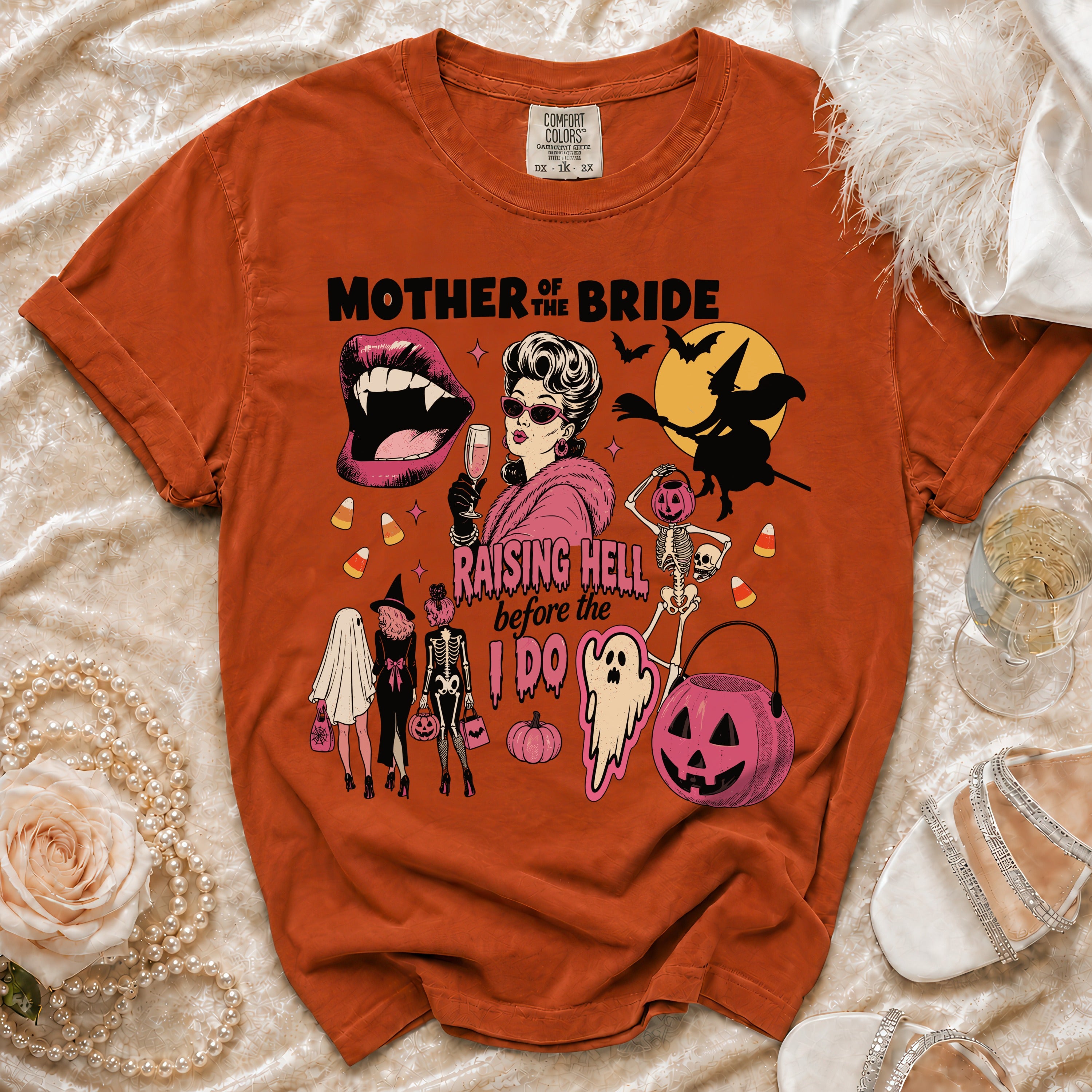Orange t-shirt with "Mother of the Bride Raising Hell Before the I Do" Halloween graphic.