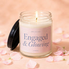 Glass jar candle with "Engaged & Glowing" label, lit flame, and pink petals.