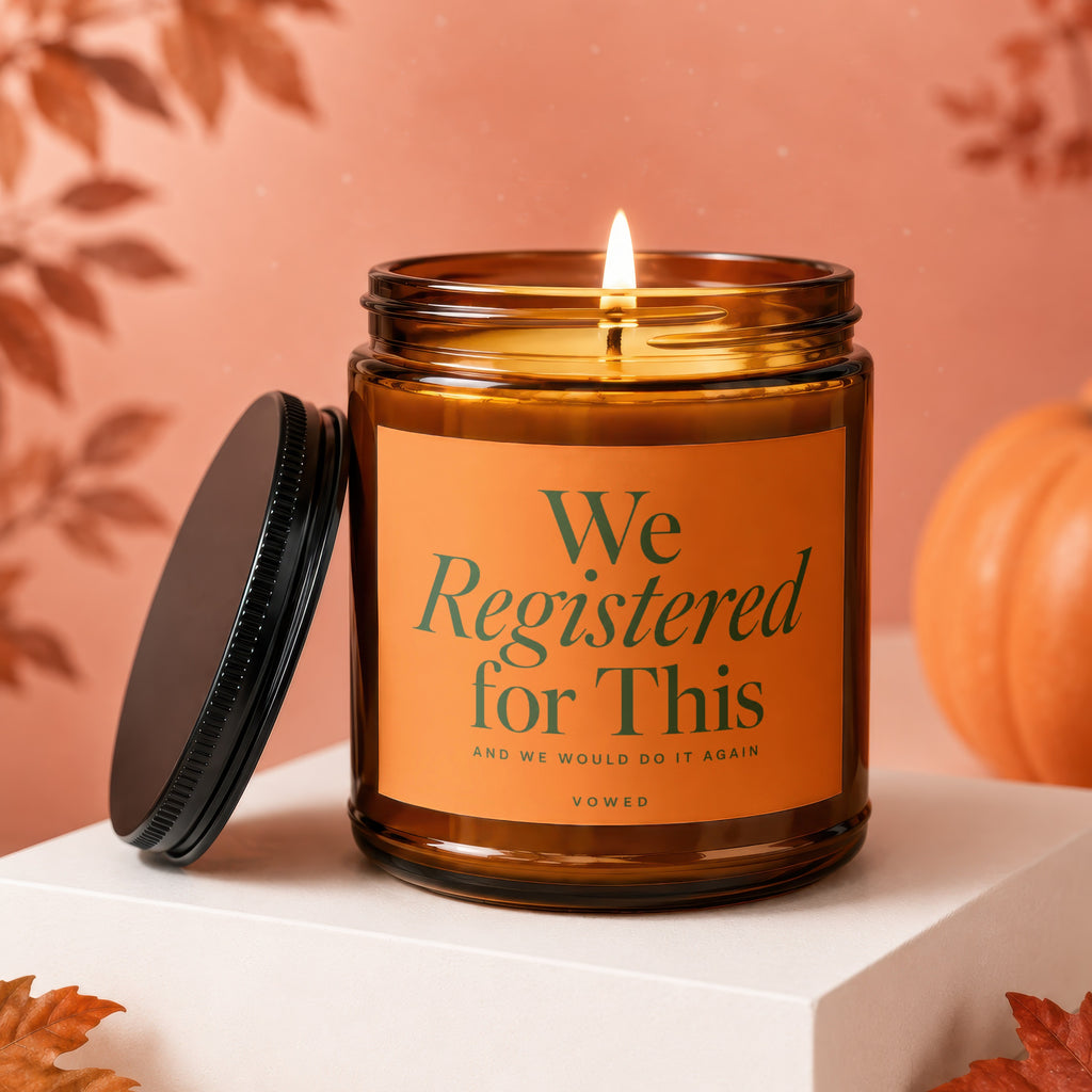 Amber candle with an orange label that reads "We Registered for This"