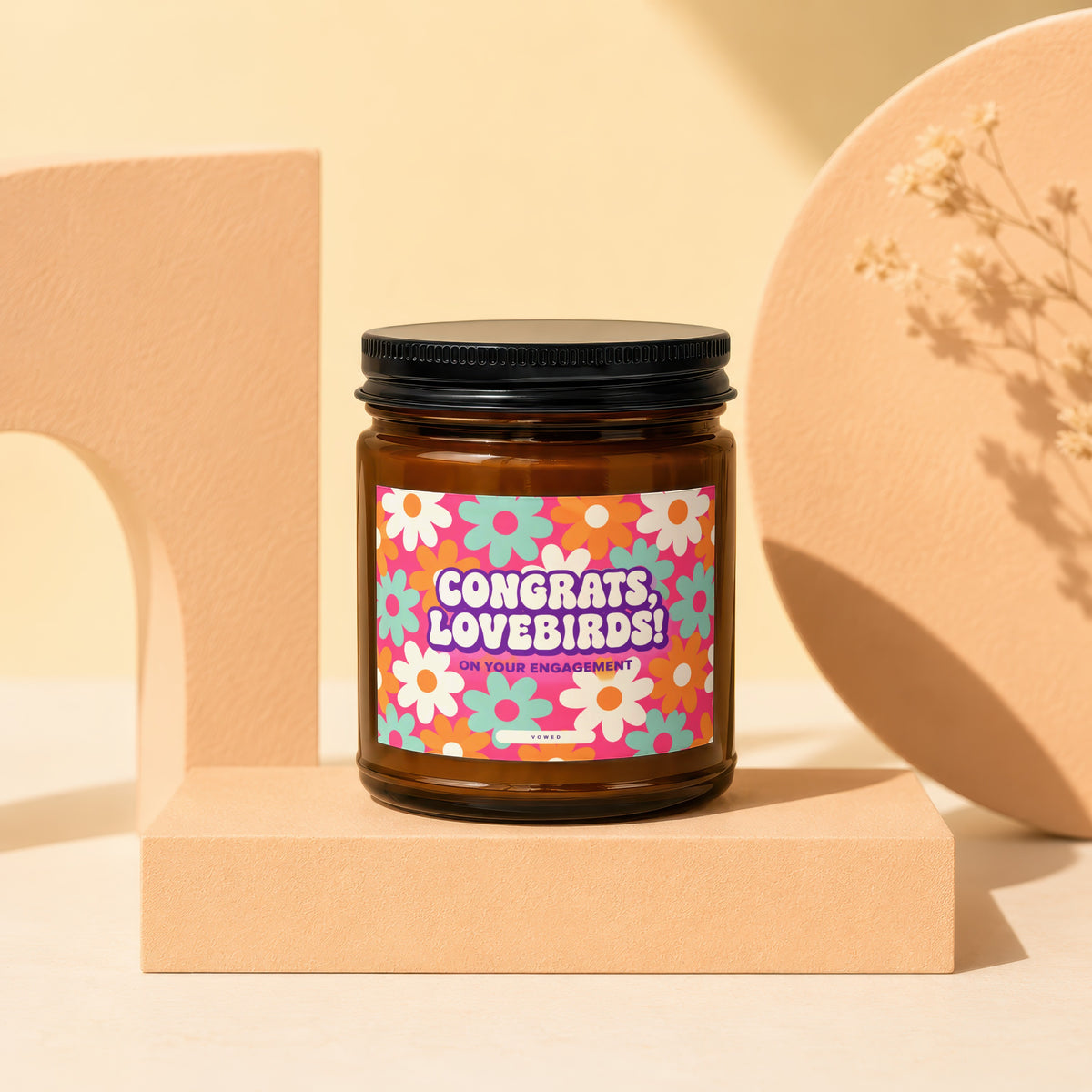 Amber jar candle with "Congrats, Lovebirds! On Your Engagement" text and floral design.