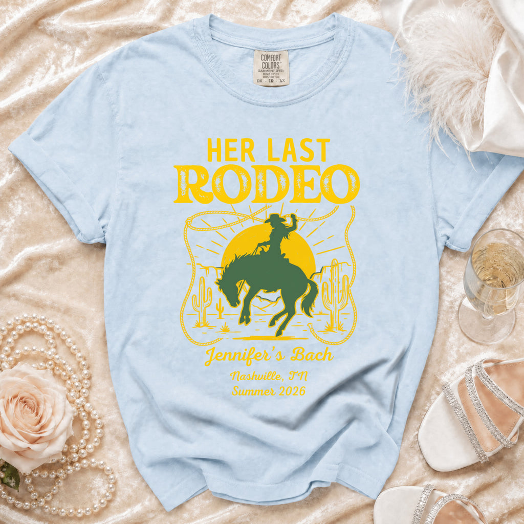 Light blue t-shirt with "HER LAST RODEO" graphic and event details.