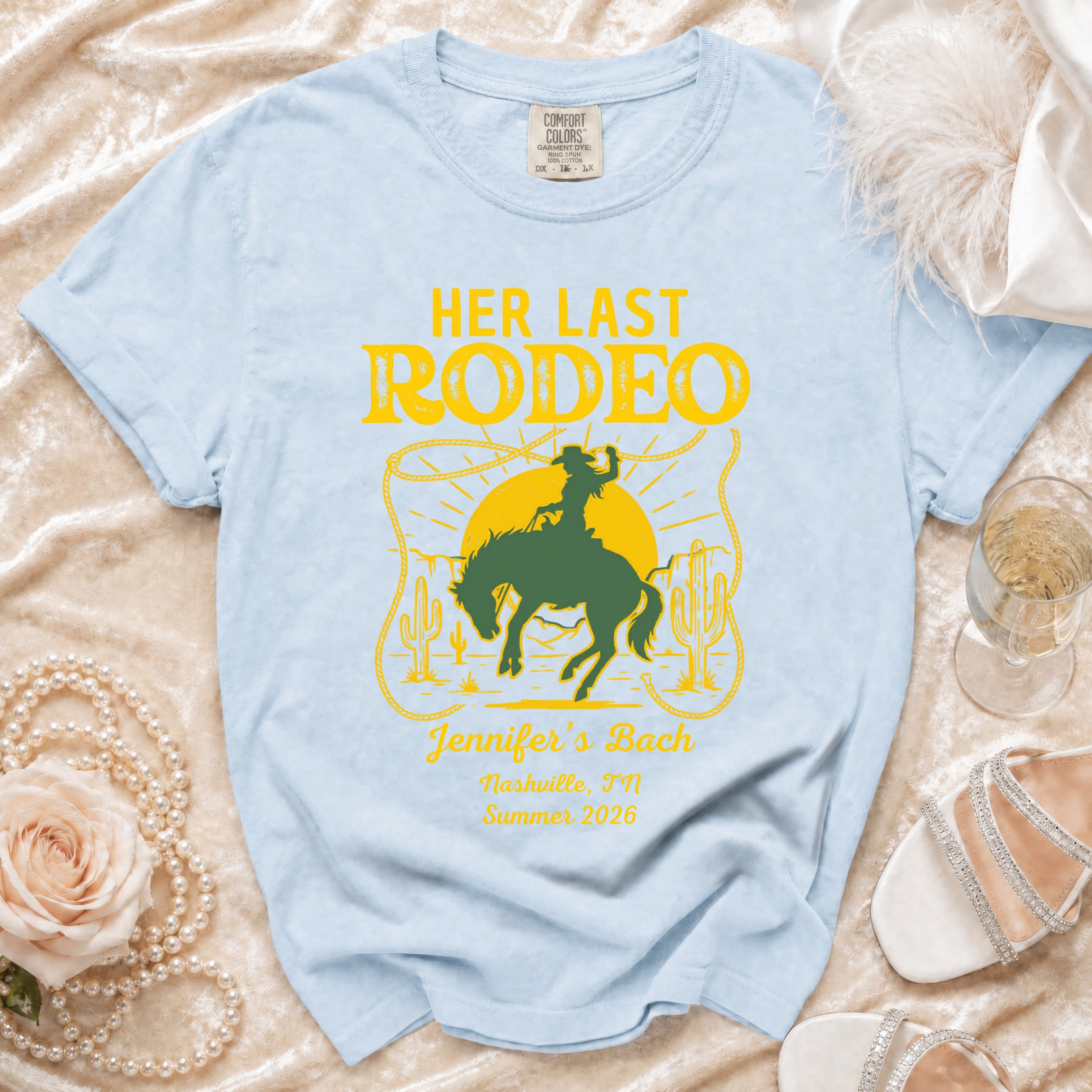 Light blue t-shirt with "HER LAST RODEO" graphic and event details.
