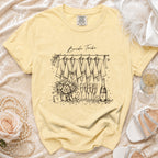 Yellow t-shirt with "Bride Tribe" text and sketch of robes, champagne, and flowers.