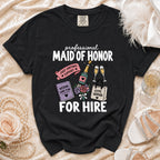 Black t-shirt reading "professional MAID OF HONOR FOR HIRE" with wedding-themed illustrations.