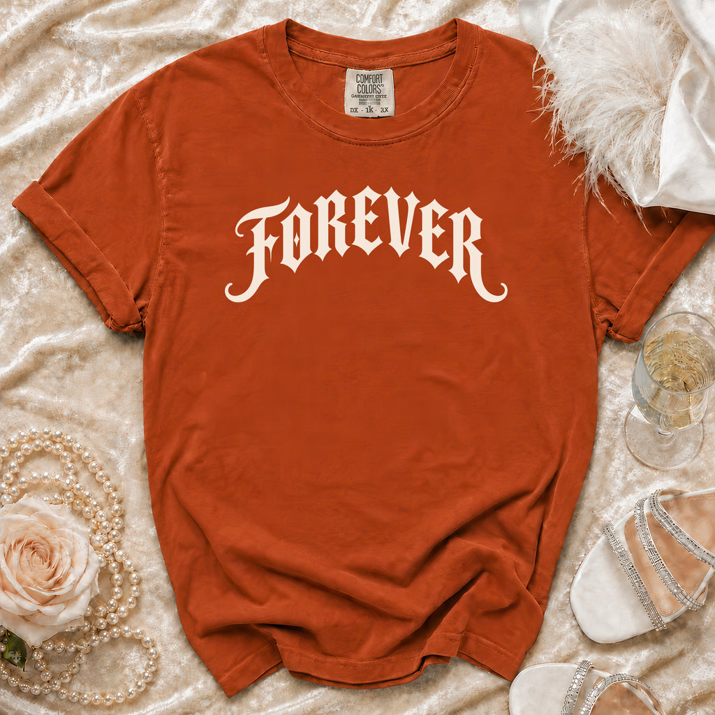 Orange t-shirt with "FOREVER" printed in white gothic font, styled with pearls and heels.