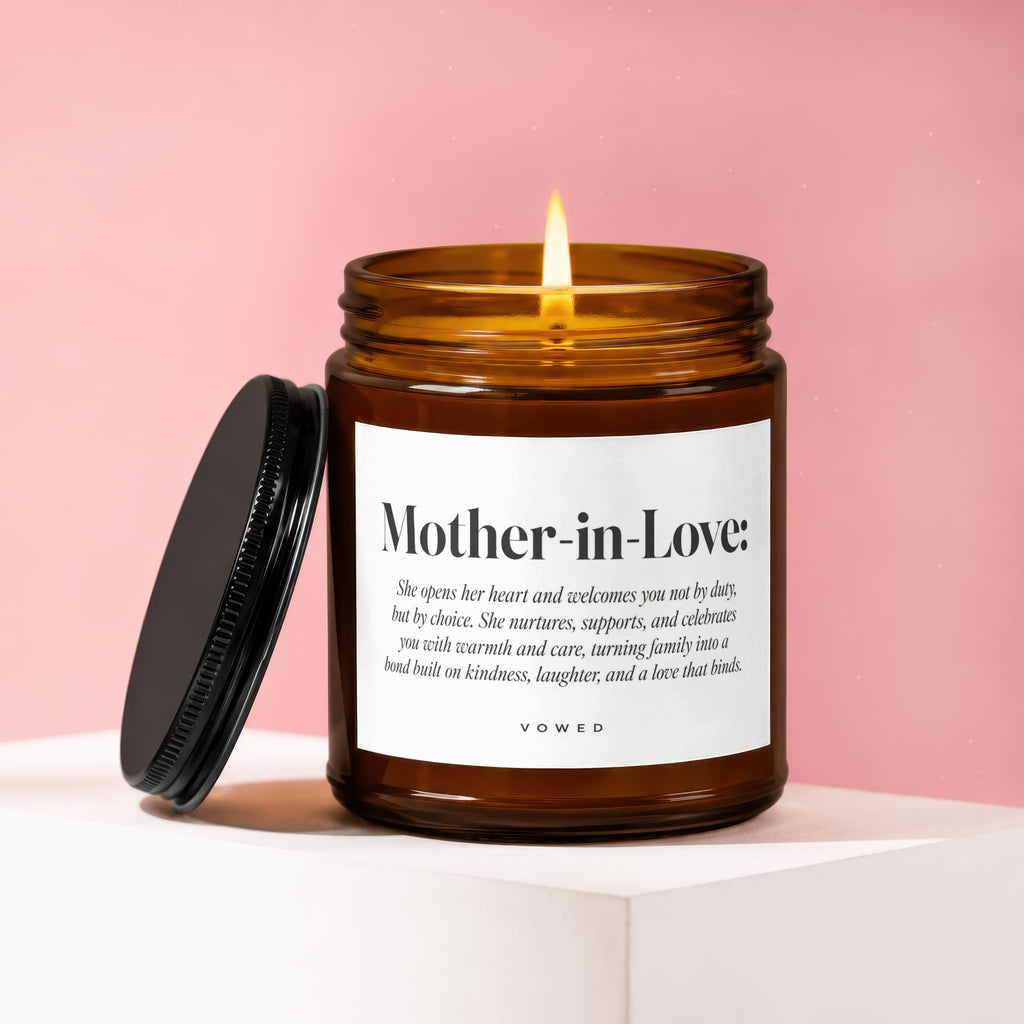 Amber glass candle with lit flame, reading "Mother-in-Love" and descriptive text.
