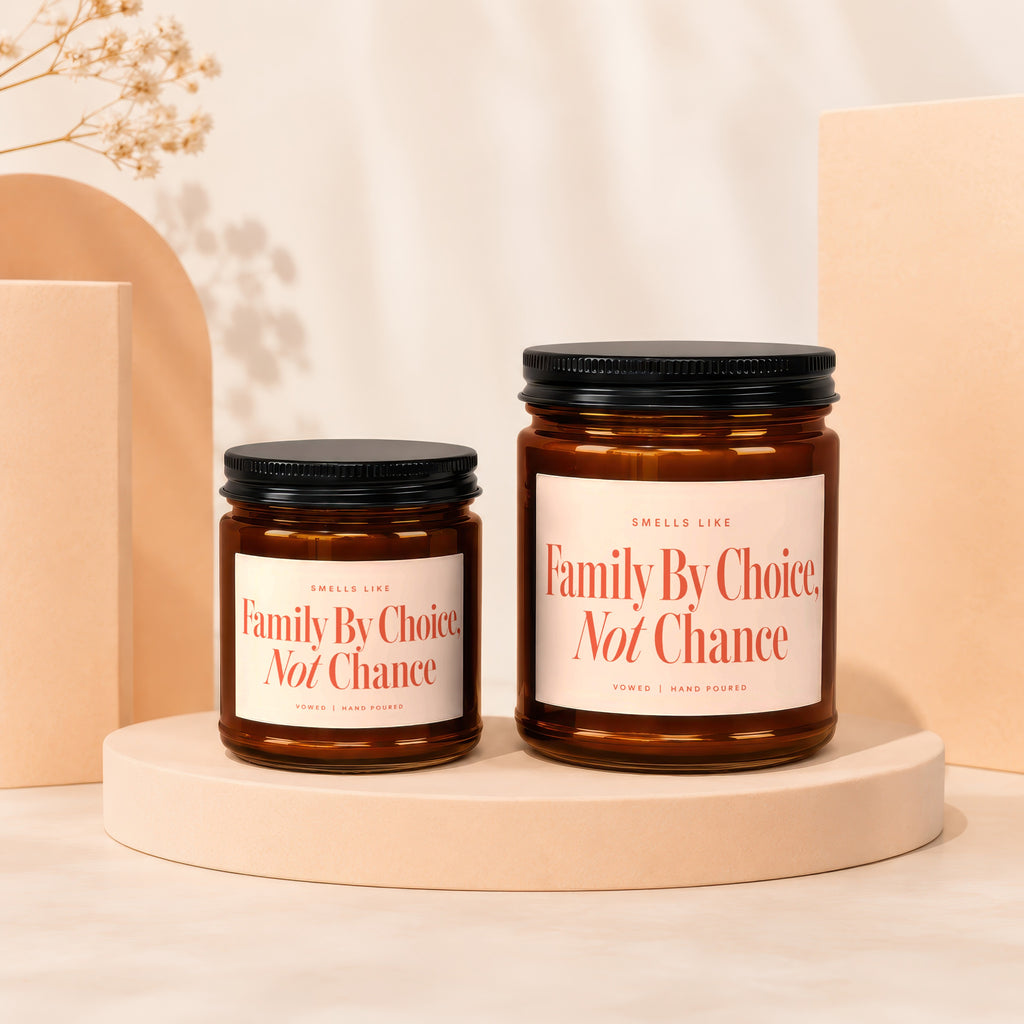 Two amber glass candles on display stands with labels reading "Family By Choice, Not Chance".