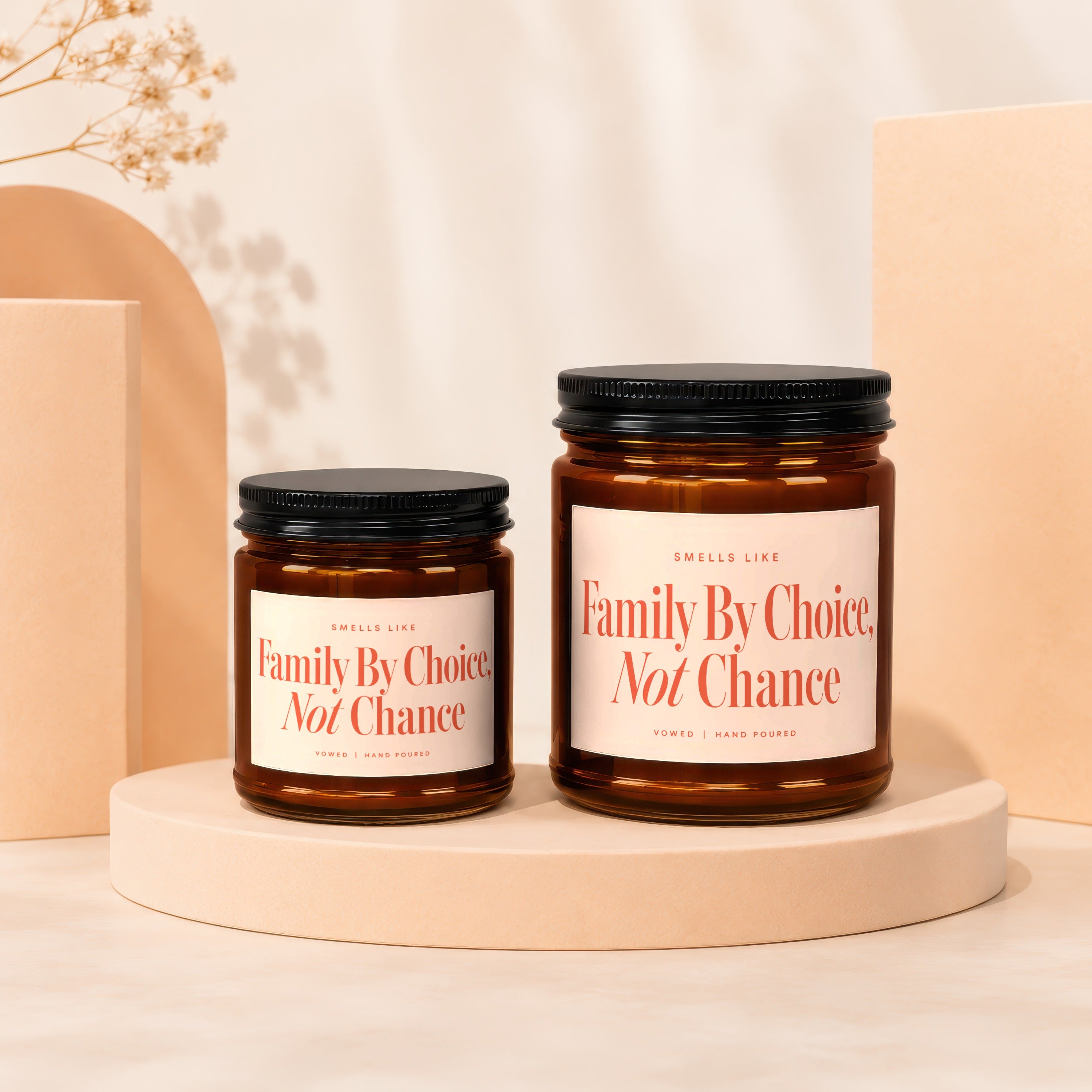 Two amber glass candles on display stands with labels reading "Family By Choice, Not Chance".