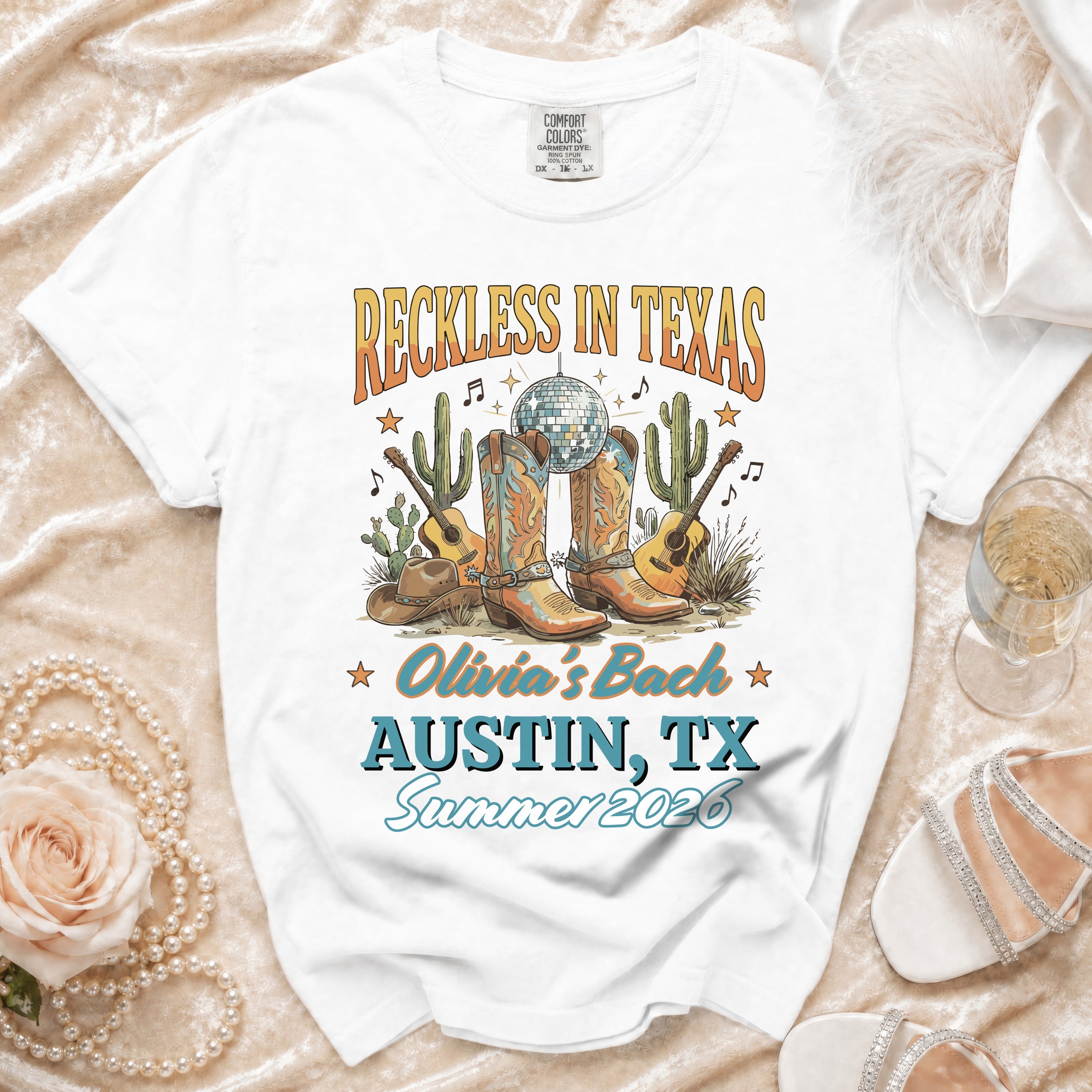 White t-shirt with "Reckless in Texas" and "Olivia's Bach Austin, TX Summer 2026".