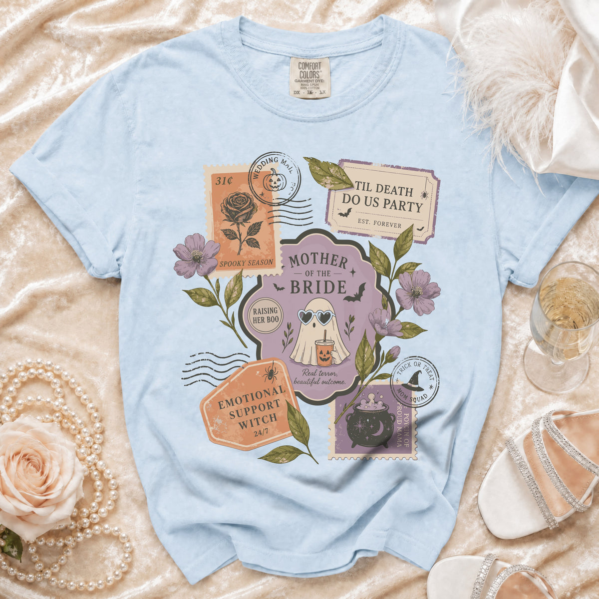 Light blue t-shirt with "Mother of the Bride" Halloween-themed graphic featuring stamps and ghost.