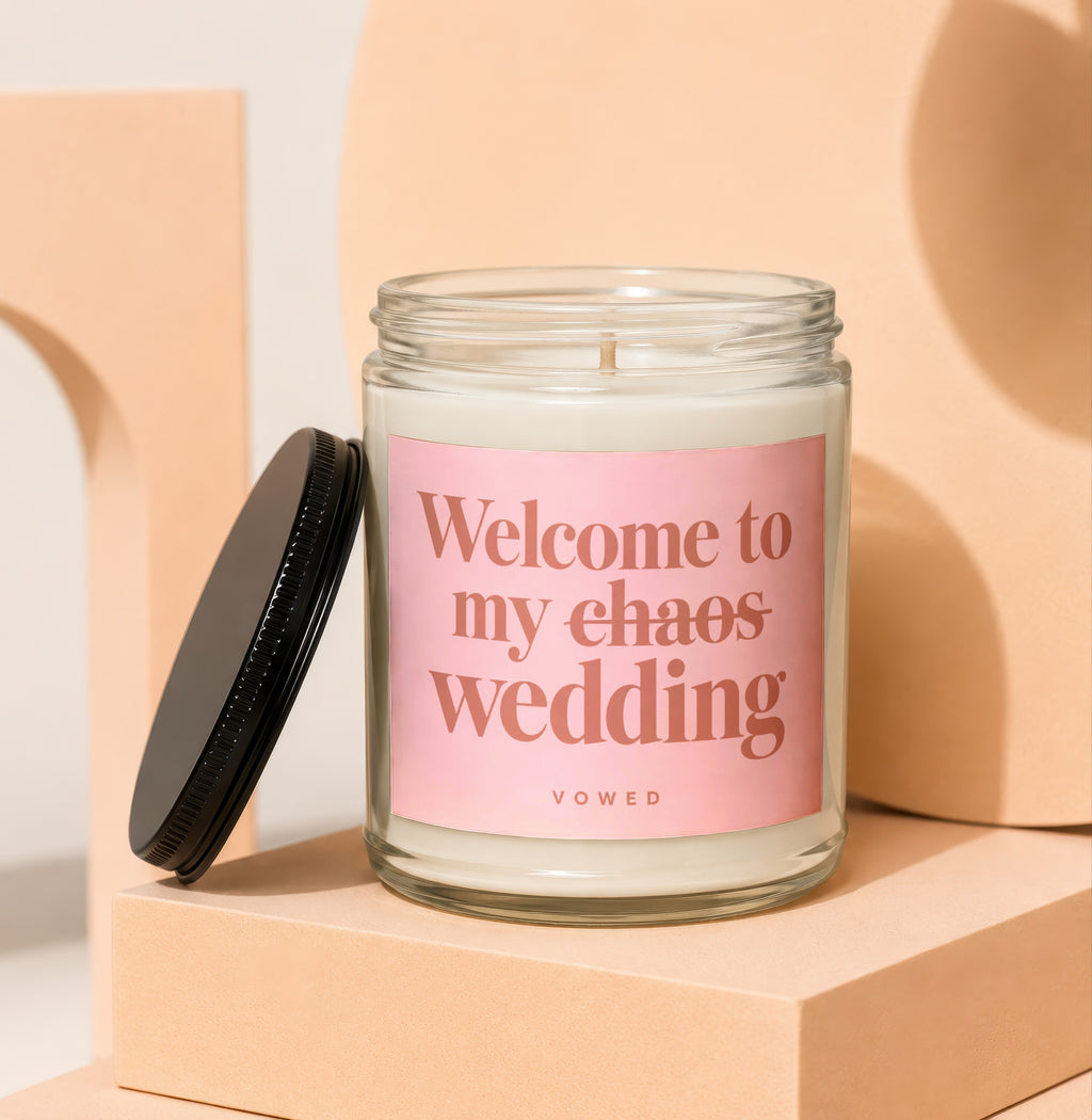 Candle with pink label reading "Welcome to my chaos wedding" VOWED.