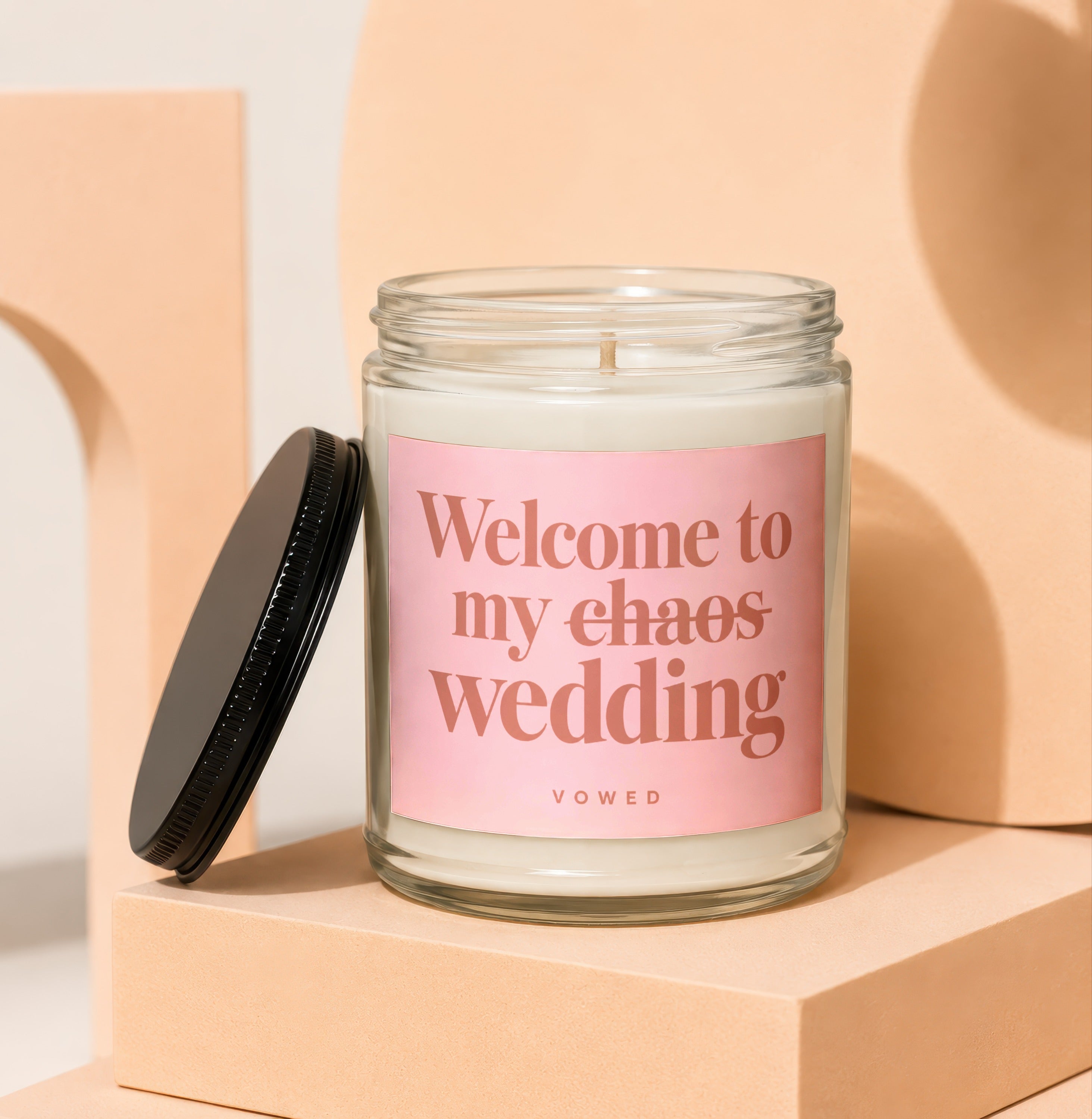 Candle with pink label reading "Welcome to my chaos wedding" VOWED.