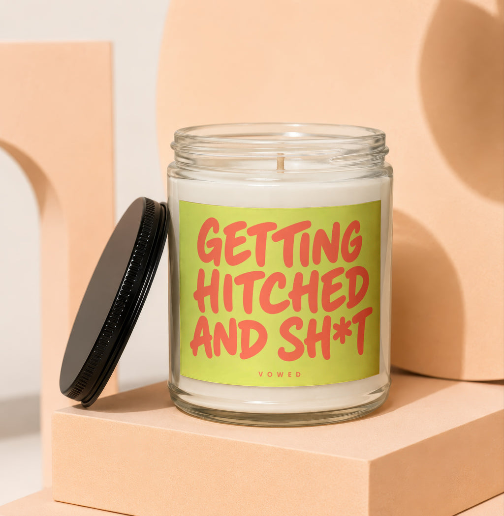 Glass candle with red text on a lime green label saying "GETTING HITCHED AND SH*T".