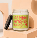 Glass candle with red text on a lime green label saying "GETTING HITCHED AND SH*T".