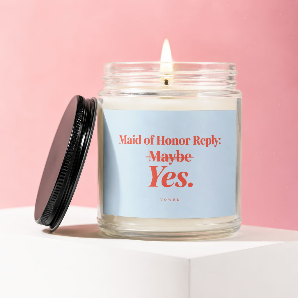 Candle with lit wick and black lid, reads "Maid of Honor Reply: Maybe Yes."