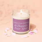 Lit candle with "Love, Laughter & Happily Ever After" text on label.