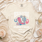 Cream t-shirt with "Reckless in Texas" graphic for Olivia's Bach, Austin, TX, Summer 2026.