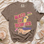Brown t-shirt with "Maid of Honour Needs a Mimosa" graphic and champagne glass.