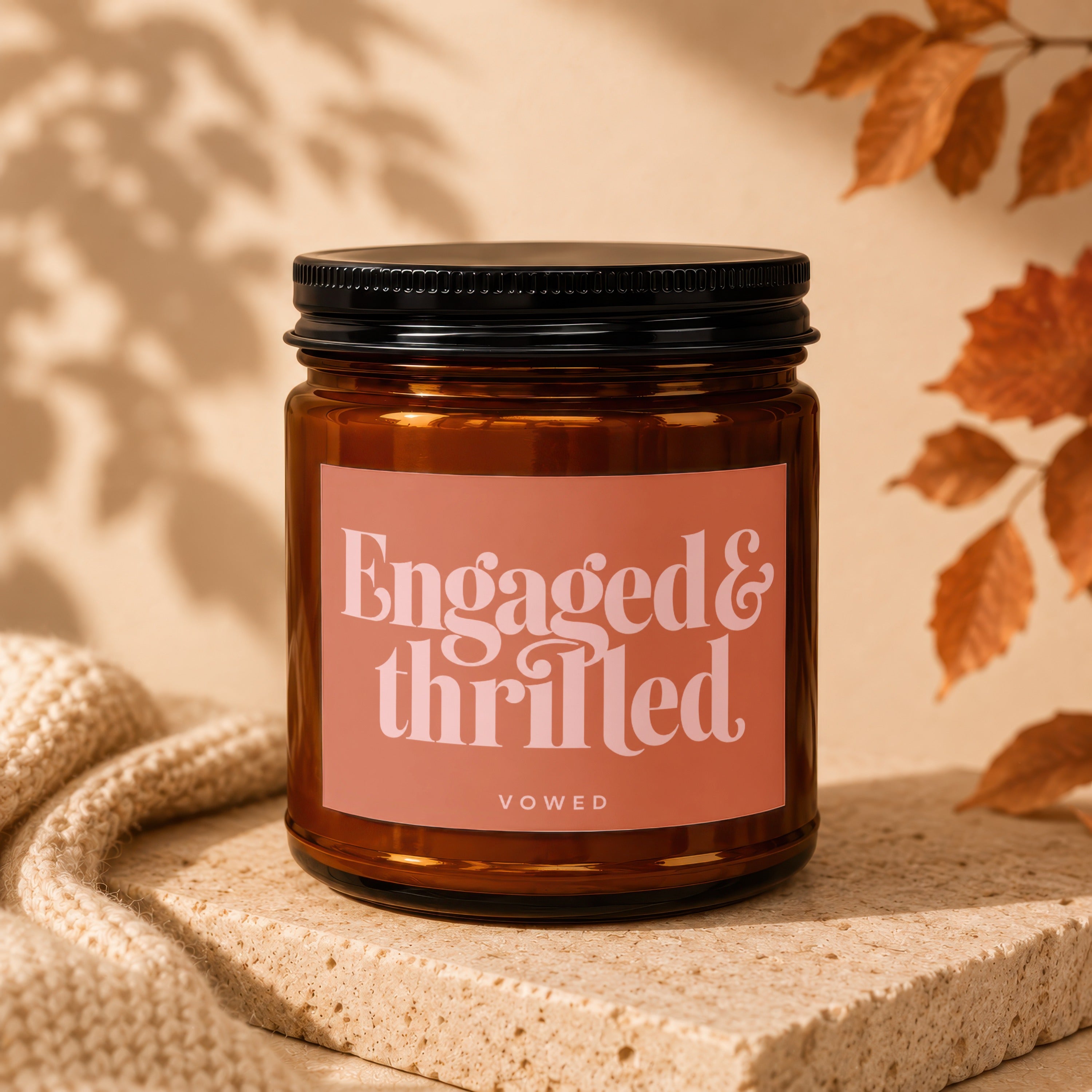 Amber candle with "Engaged & thrilled" text and "VOWED" below on salmon label.