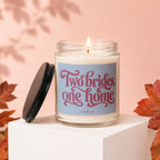 Candle with text "Two brides, one home VOWED" on a pink background.